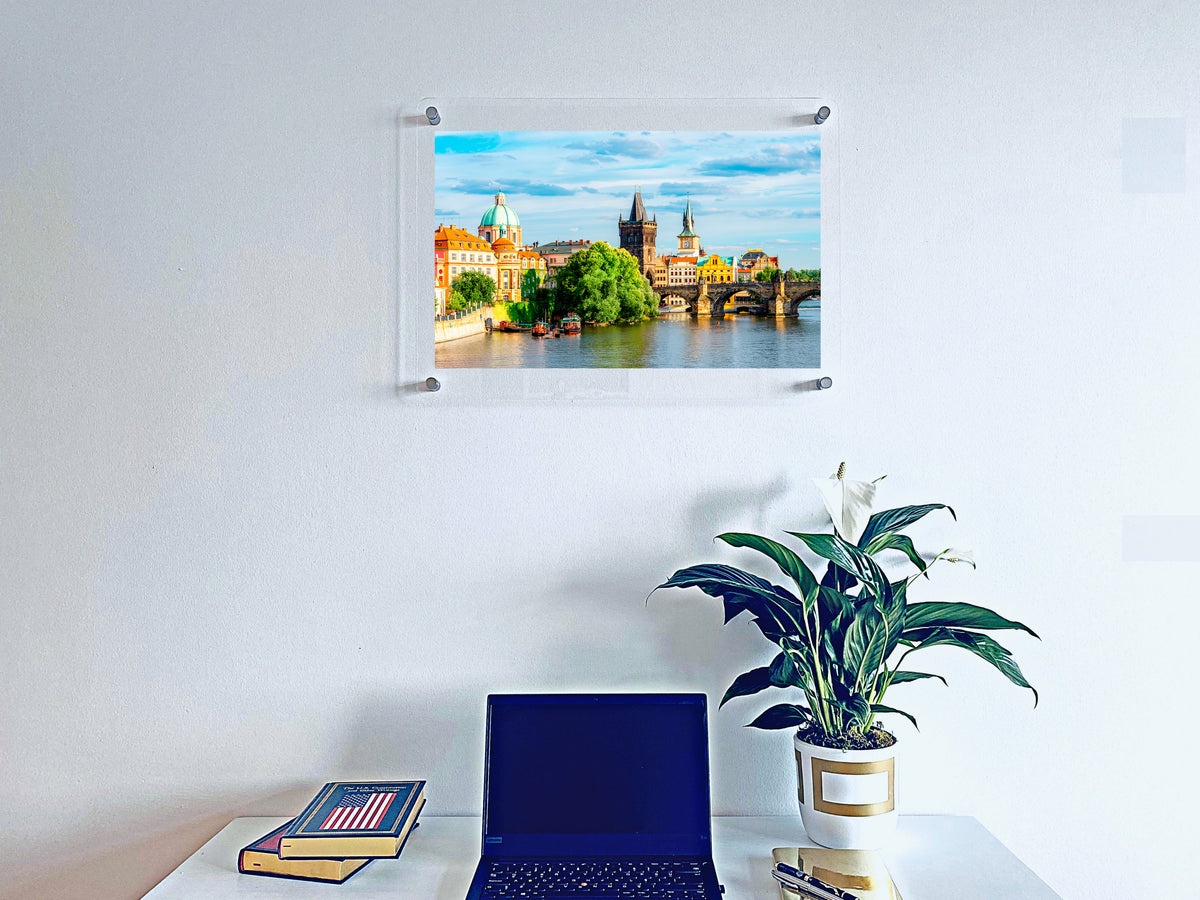 Acrylic photo wall art displayed above a desk with a laptop and plant.