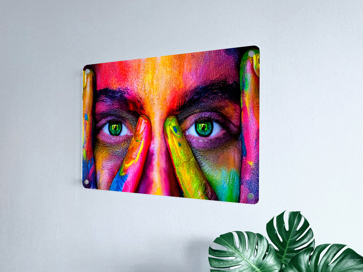 Vivid multicolor portrait printed on an acrylic wall panel beside a leafy plant.