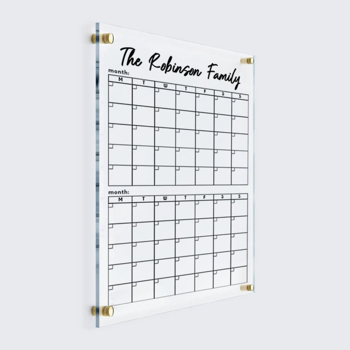 Personalized vertical acrylic calendar with two monthly grids stacked below a custom family heading and gold wall mounts.