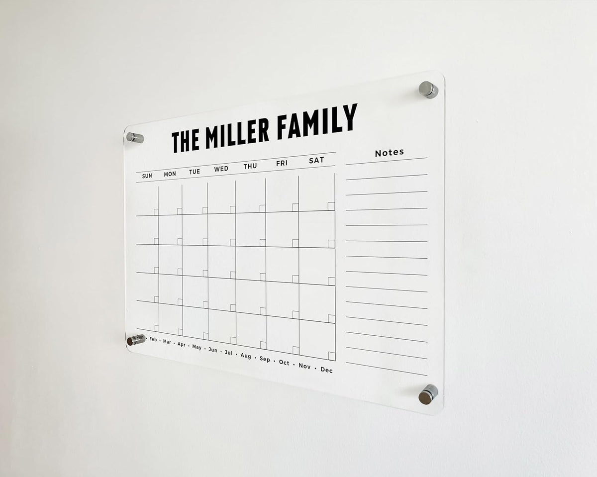 Angled detail of an acrylic monthly family calendar showing a full-height lined side section and month labels along the bottom.