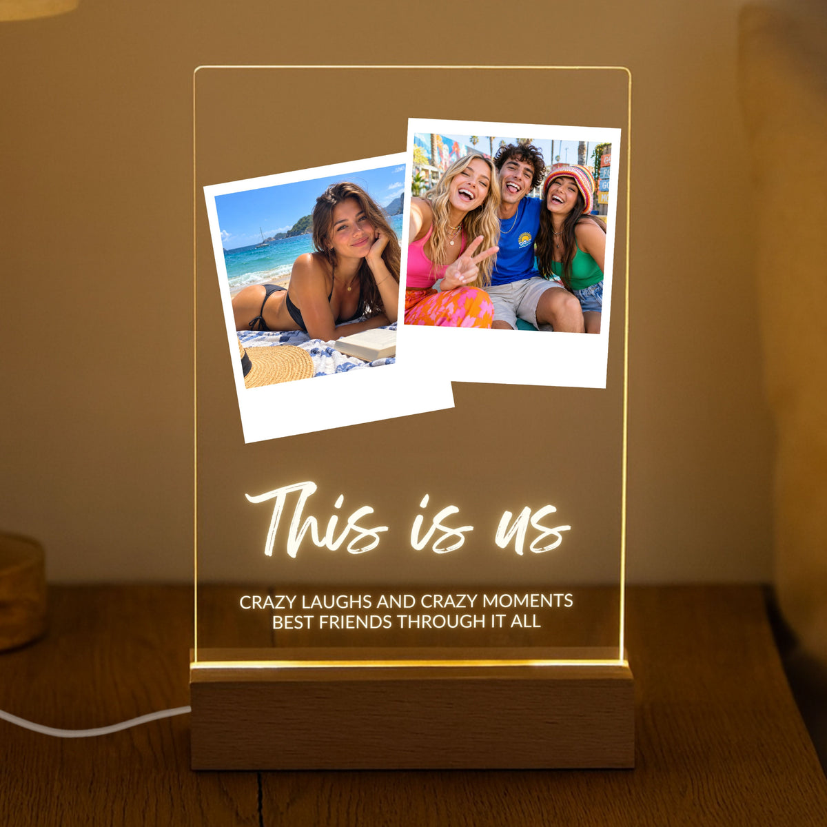 Two Photo Collage Plaque - Brush Script glowing on a wooden LED stand in a dark room with the sample text This is us