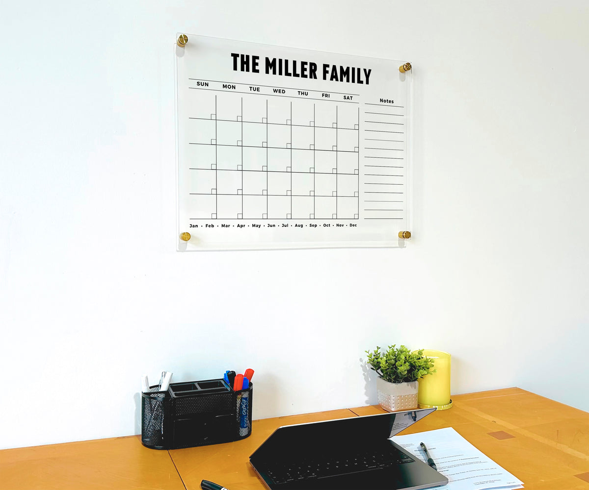 Personalized monthly acrylic calendar with a lined side list displayed above a home office desk.