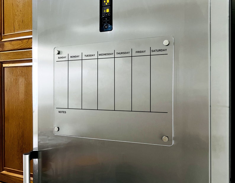 Magnetic acrylic fridge board with a seven vertical weekday columns and a notes section along the bottom.