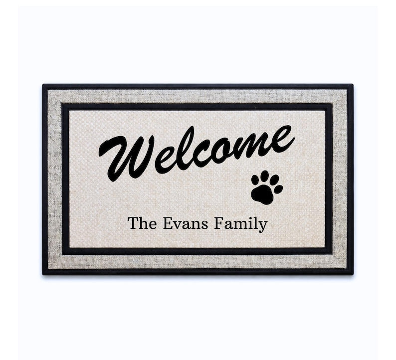 18 x 30 inch polyester doormat featuring a script Welcome, a paw print and your family name.