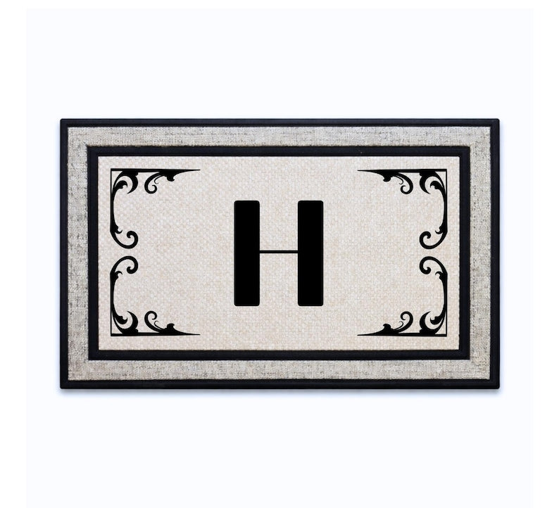 18 x 30 inch polyester doormat featuring a single initial surrounded by ornate corner flourishes.