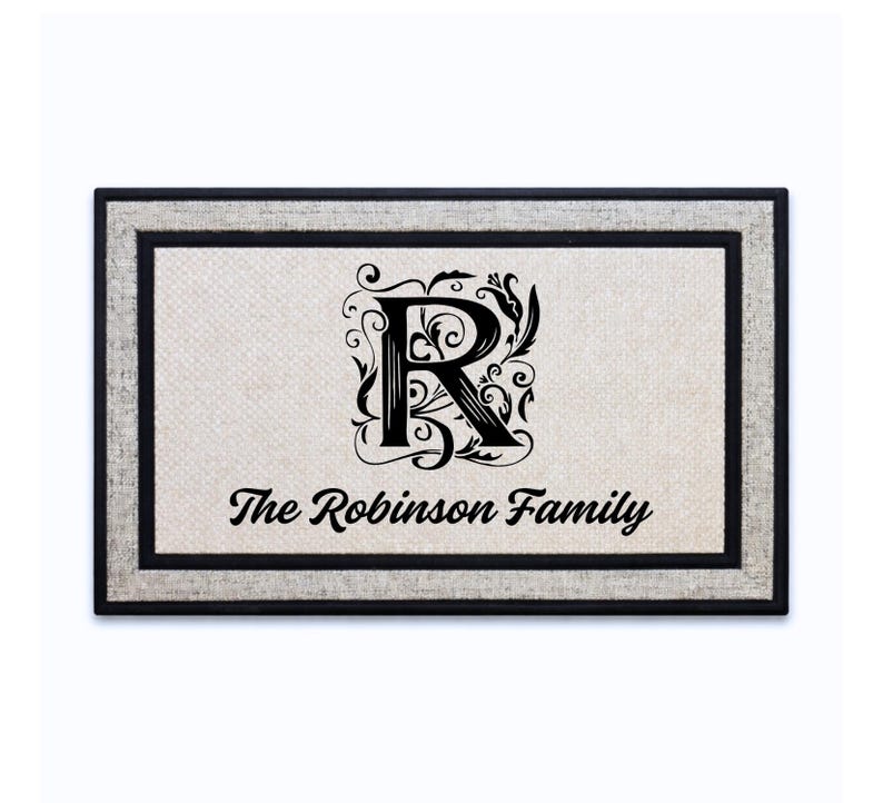 18 x 30 inch polyester doormat featuring a decorative initial with a family name underneath.