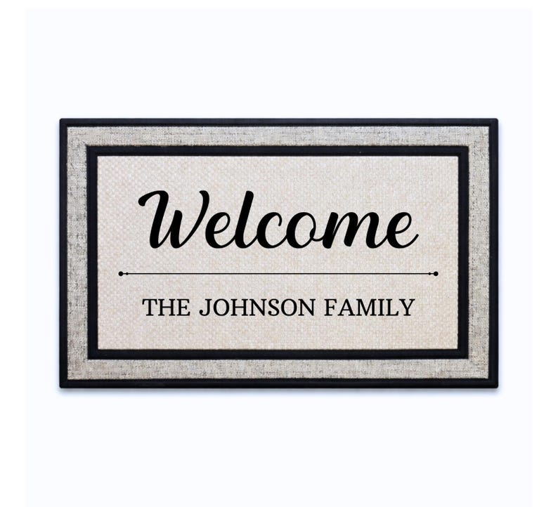 18 x 30 inch polyester doormat featuring a script Welcome above a dividing line and family name.