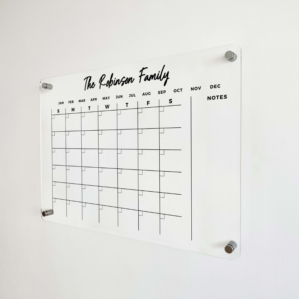 Front detail of an acrylic family calendar with small date boxes, month labels and one open side section.